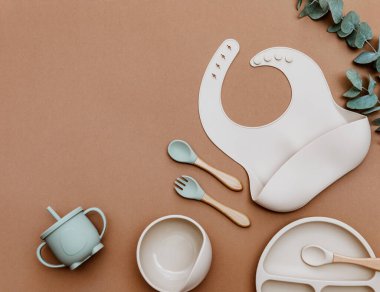 Kahverengi arkaplanda yeşil bulaşık takımları, metin için yeri olan düz yataklar. İlk yemek servisini yapıyorum.