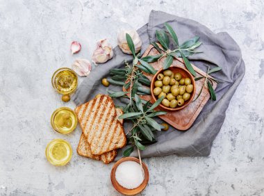 Zeytinyağı ve taze zeytin dalı. Beyaz mermer arka planda. Taze zeytinyağı test ediliyor..