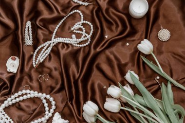 Cazibeli ipek arka planda kadın aksesuarları ve laleler yatıyordu. Sevgililer günü ve kadınlar günü konsepti. Güzellik blogcusu 