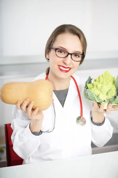 Jovem nutricionista mostrando repolho romano — Fotografia de Stock