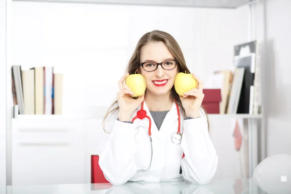 Nutricionista joven mostrando manzana —  Fotos de Stock