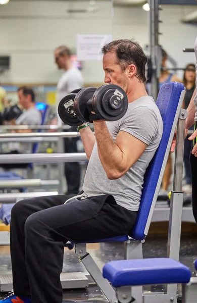 Portret van een gespierde man training met barbell op sportschool — Stockfoto