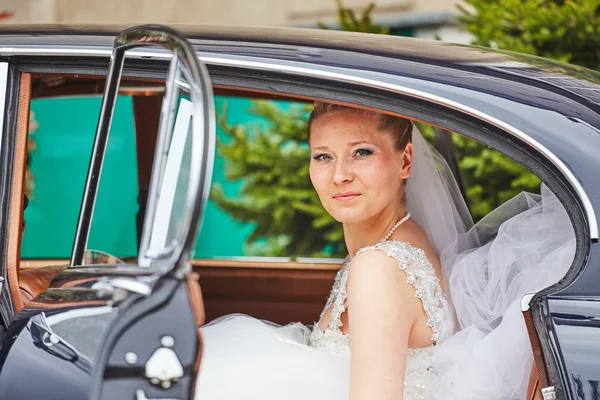 Hermosa novia rubia posando dentro de coche — Foto de Stock