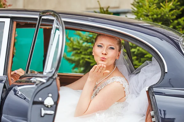 Mooie blonde bruid poseren in auto — Stockfoto