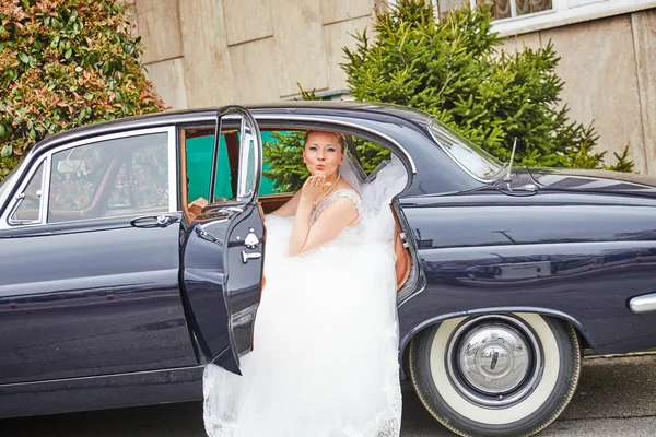 Beautiful blond bride posing inside car — Stock Photo, Image