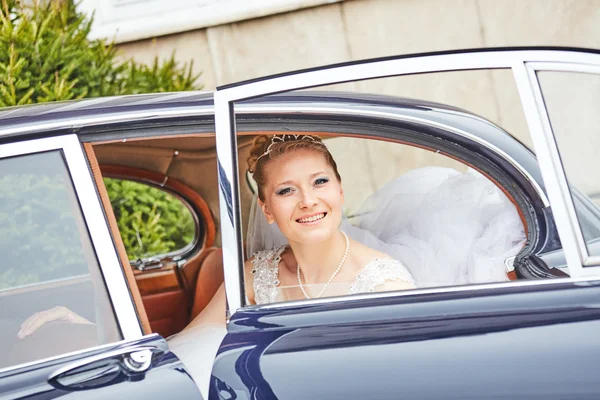 Beautiful blond bride posing inside car — Stock Photo, Image