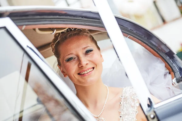 Mooie blonde bruid poseren in auto — Stockfoto