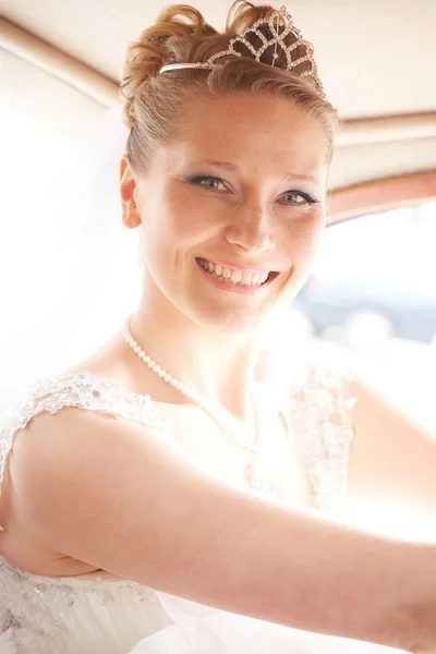 Beautiful blond bride posing inside car — Stock Photo, Image