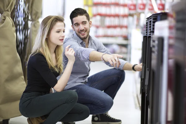 Young couple buying at hardware store — Stock Photo, Image