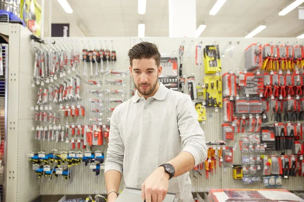 Молодой человек работает в магазине бытовой техники — стоковое фото