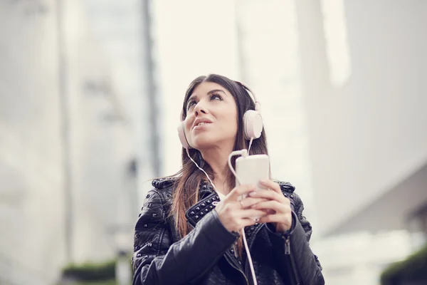 Mujer joven escuchando música por teléfono inteligente —  Fotos de Stock