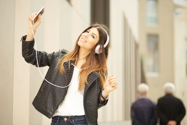 Mujer joven escuchando música por teléfono inteligente —  Fotos de Stock