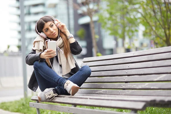 Mujer joven escuchando música por teléfono inteligente —  Fotos de Stock