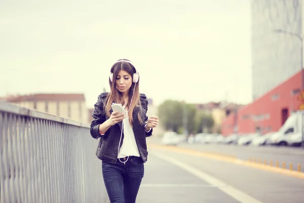 Mujer joven escuchando música por teléfono inteligente —  Fotos de Stock