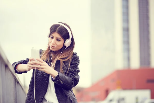 Mujer joven escuchando música por teléfono inteligente —  Fotos de Stock