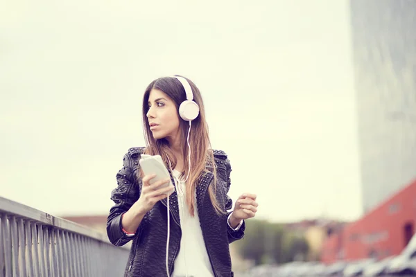 Mujer joven escuchando música por teléfono inteligente —  Fotos de Stock