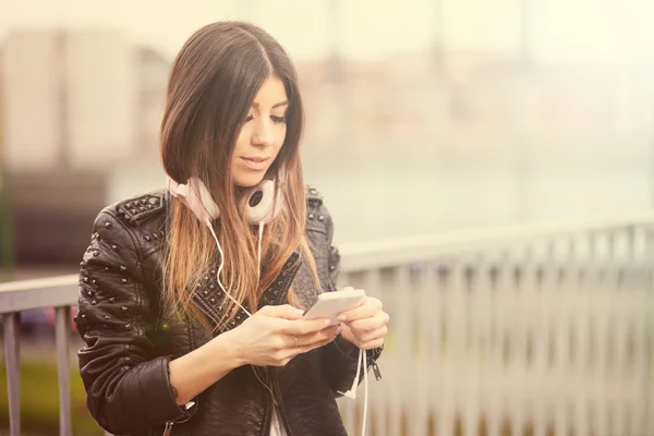 Молодая женщина слушает музыку по смартфону — стоковое фото