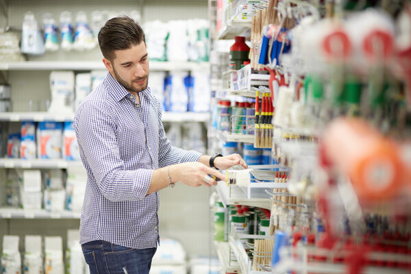 молодой человек работает в магазине бытовой техники
