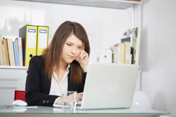 Молодая деловая женщина выглядит напряженной, когда работает за компьютером. — стоковое фото