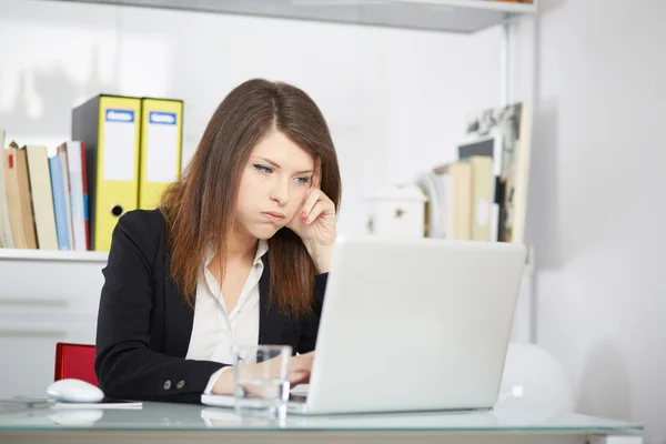 Uma jovem empresária parece estressada enquanto trabalha em seu computador — Fotografia de Stock