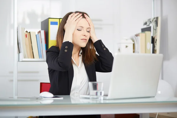 Uma jovem empresária parece estressada enquanto trabalha em seu computador — Fotografia de Stock