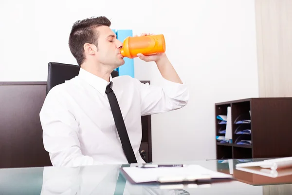 Moderner Geschäftsmann schüttelt und trinkt Proteingetränk nach dem Fitnesstraining — Stockfoto