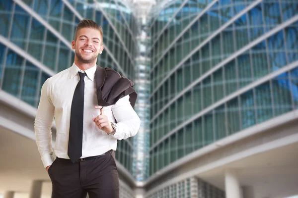Young businessman standing outside office building — Stock Photo, Image