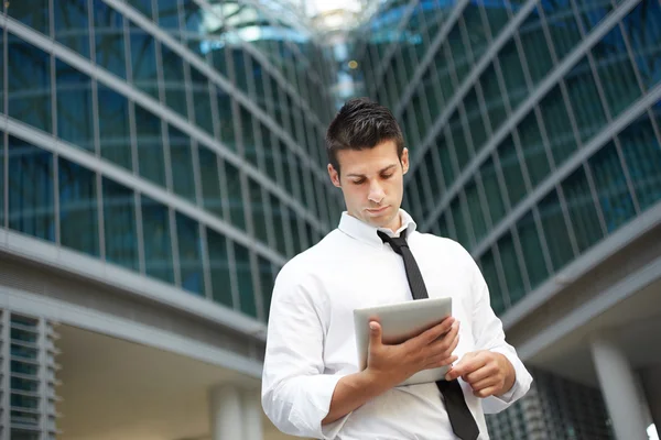 Empresário usando tablet digital fora do prédio de escritórios — Fotografia de Stock