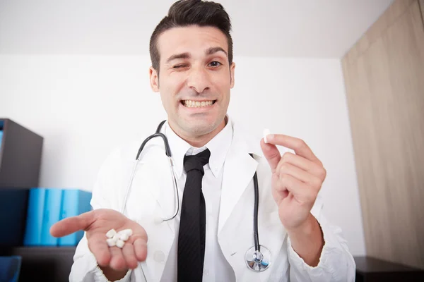 Médico loco mostrando pastillas —  Fotos de Stock