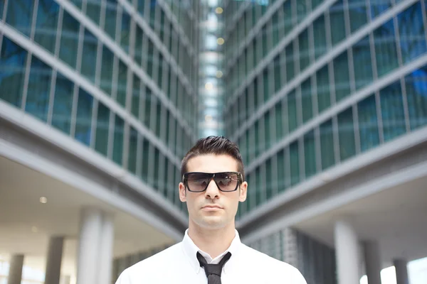 Jeune homme d'affaires debout devant un immeuble de bureaux — Photo