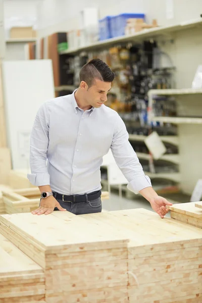 Kund på järnaffär söka trämaterial — Stockfoto