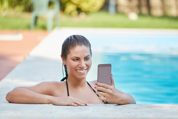 Jovem mulher tomando uma selfie na piscina — Fotografia de Stock