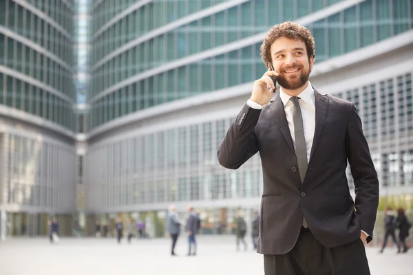 Geschäftsmann im Gespräch mit mobilen Bürogebäuden — Stockfoto