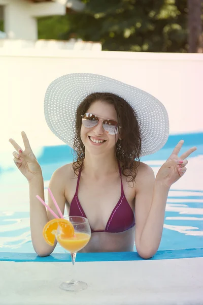 Gelukkig lachende vrouw met stro hoed in zwembad — Stockfoto
