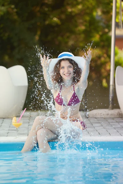 Ung kvinna avkopplande i poolen — Stockfoto