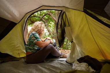 Kız ormanda çadırın dışında bizi izliyor.