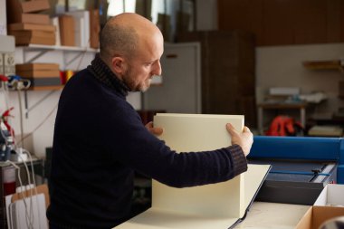 Bir el sanatları atölyesinde çalışan bir kitap klasörü