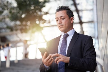 Kentsel çevrede cep telefonuyla konuşan iş adamı