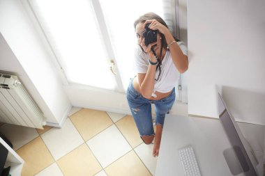 Genç profesyonel fotoğrafçı ev stüdyosunda çalışıyor.