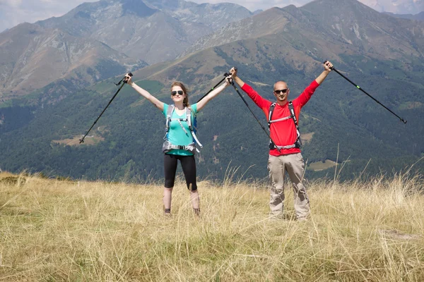 Pareja de excursionistas caminando por la montaña — Foto de Stock