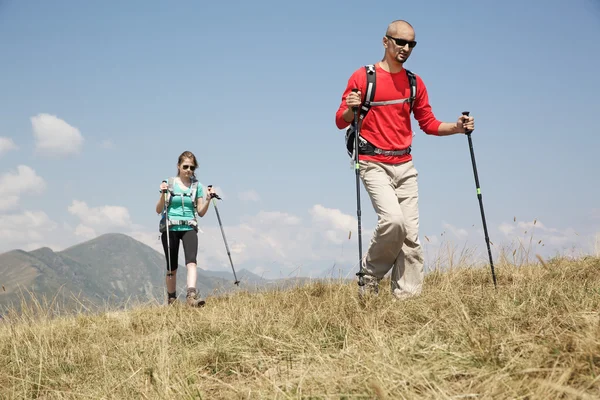 Pareja de excursionistas caminando por la montaña — Foto de Stock