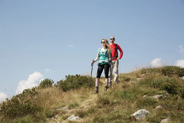 Pareja de excursionistas caminando por la montaña — Foto de Stock