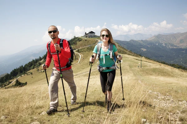 Pareja de excursionistas caminando por la montaña — Foto de Stock