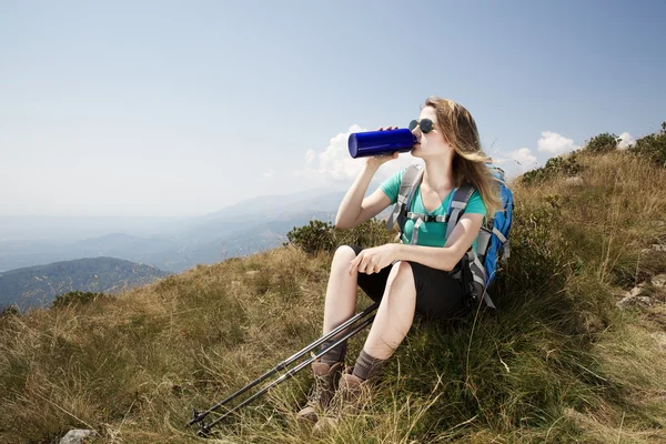 Женщина-турист, идущая через горы — стоковое фото