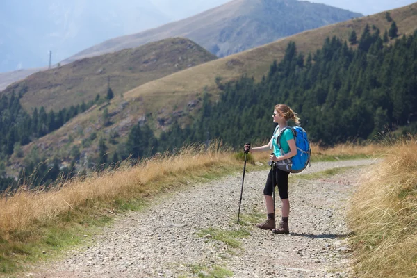 Mujer excursionista caminando por las montañas — Foto de Stock