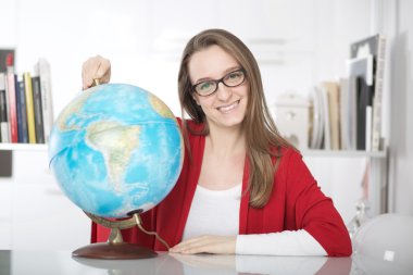 Genç güzel kız öğrenci bir şey üzerinde dünya işaret