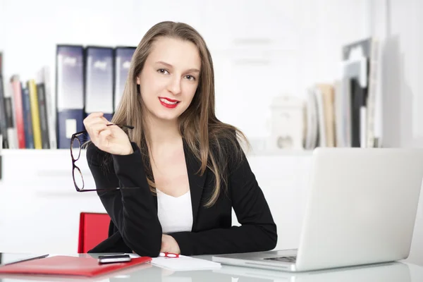 Empresária usando laptop em um escritório — Fotografia de Stock