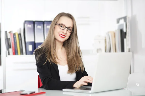 Empresaria usando laptop en una oficina —  Fotos de Stock