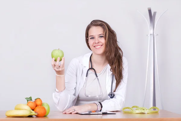 Bir elma gösterilen genç beslenme uzmanı doktor — Stok fotoğraf