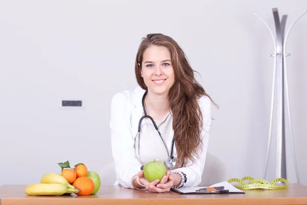 Bir elma gösterilen genç beslenme uzmanı doktor — Stok fotoğraf